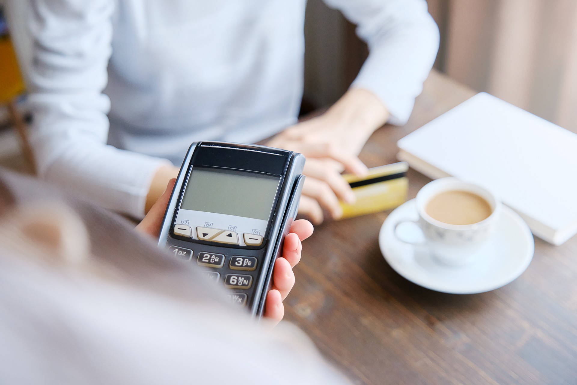 30 years old woman paying with contactless credit card in cafe